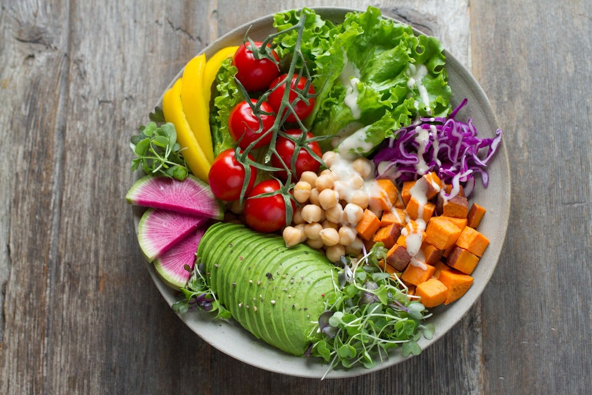 A bowl of mixed raw vegetables and leaves