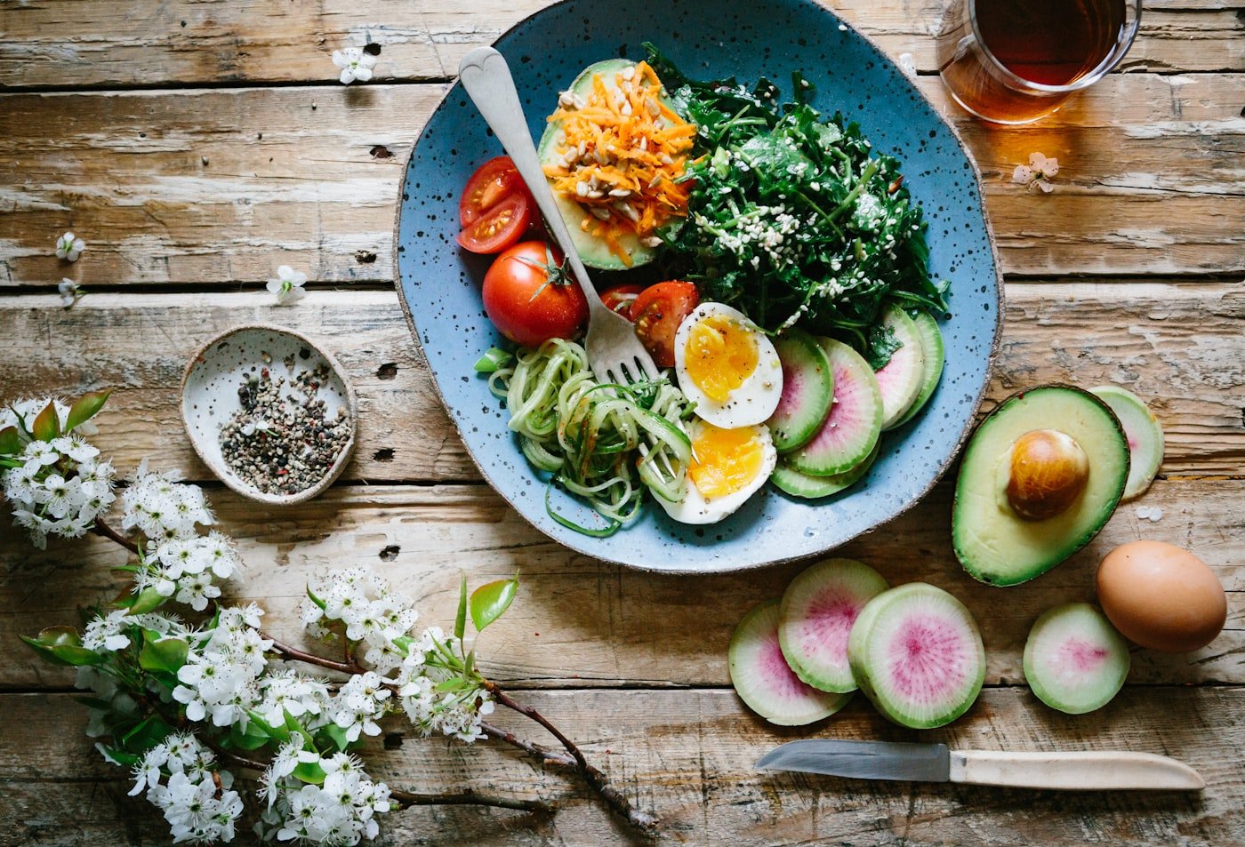 An overhead view of fresh vegetables and whole foods on a table