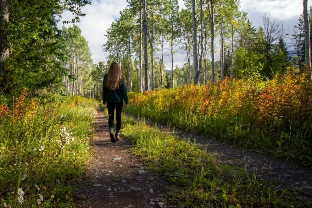 Person walking on a green outdoor path as part of a regular walking habit